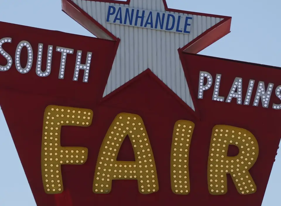 The Panhandle South Plains Fair sign: a red marquee with a white star and yellow bulb letters spelling FAIR